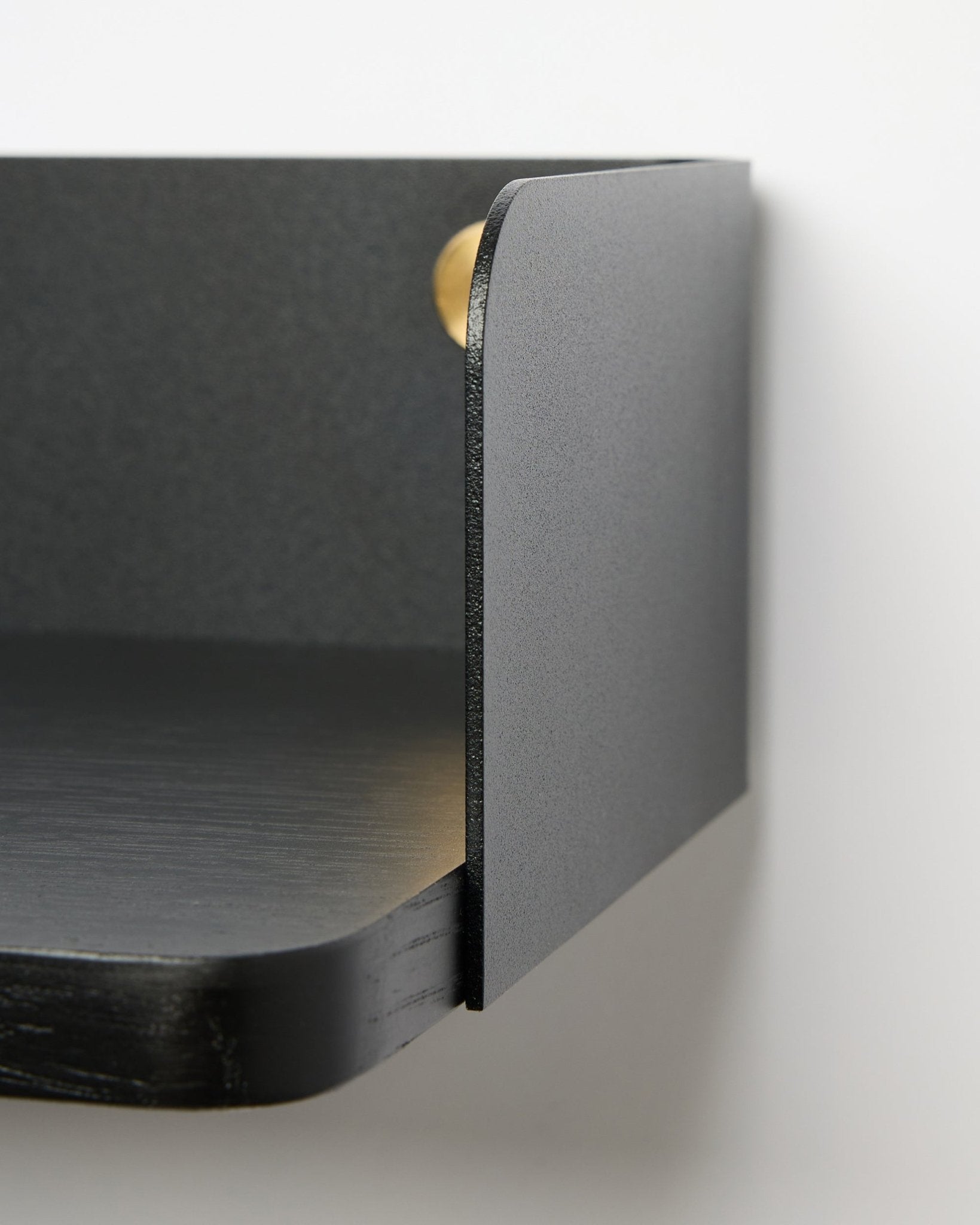 Close-up of the WoodUpp Linn Bookshelf in Black Oak, 39.9 cm wide with rounded edges and matte finish, mounted on a white wall. Nordic minimalist style.