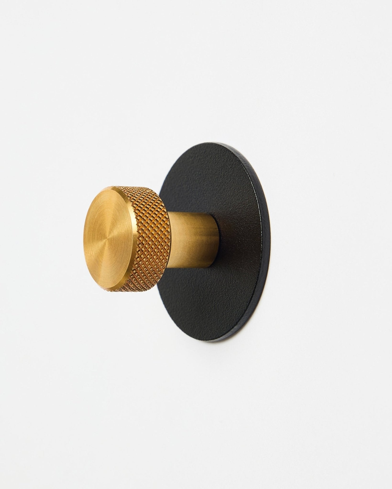 Norr Coat Hook X1 by WoodUpp with a textured brass knob and black powder-coated steel base, accessory for Akupanel, displayed on a white background.