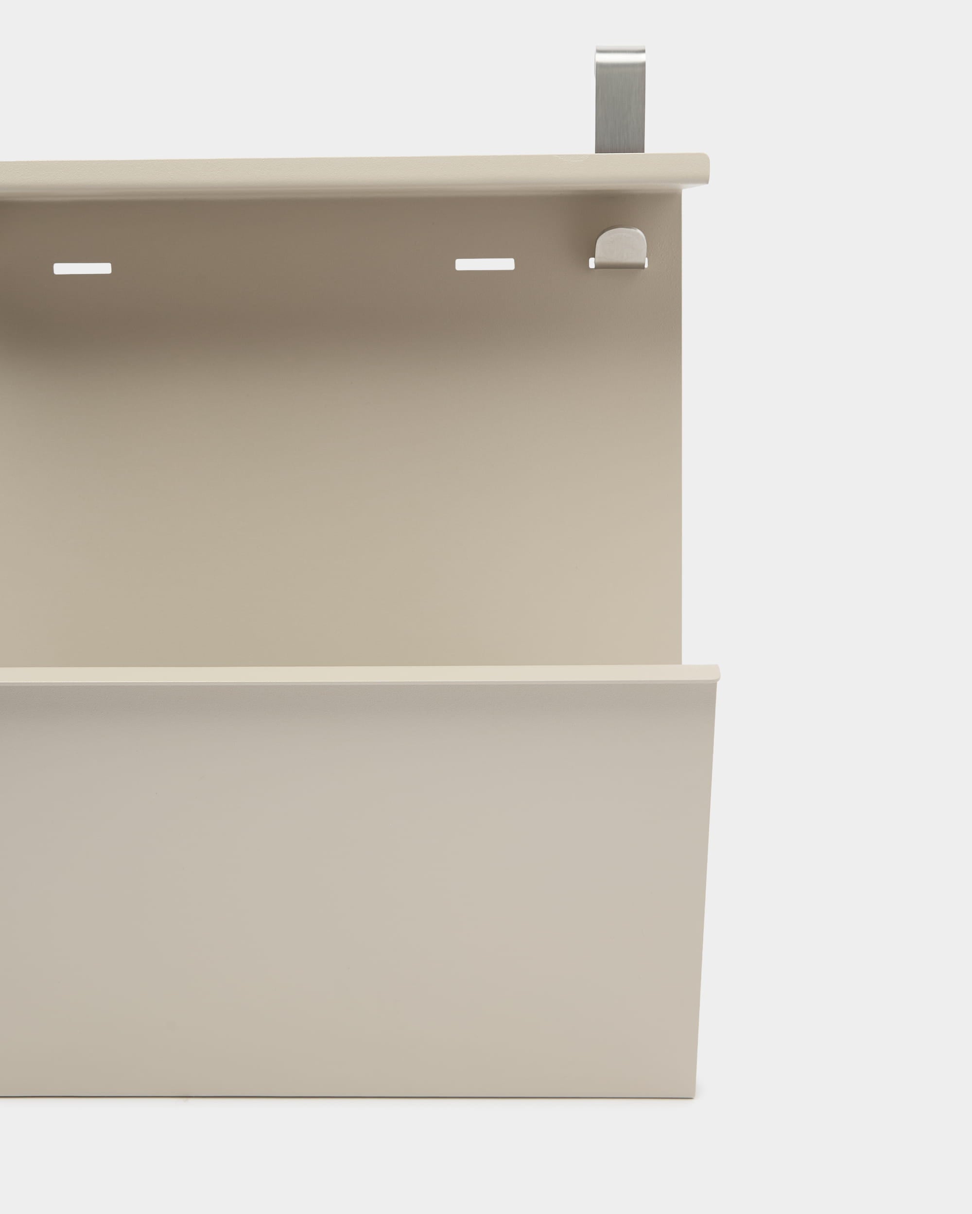 The Nell Shoe Storage by WoodUpp is a beige steel wall-mounted organizer with shelf, slots, and hook for storing shoes or organizing small items.