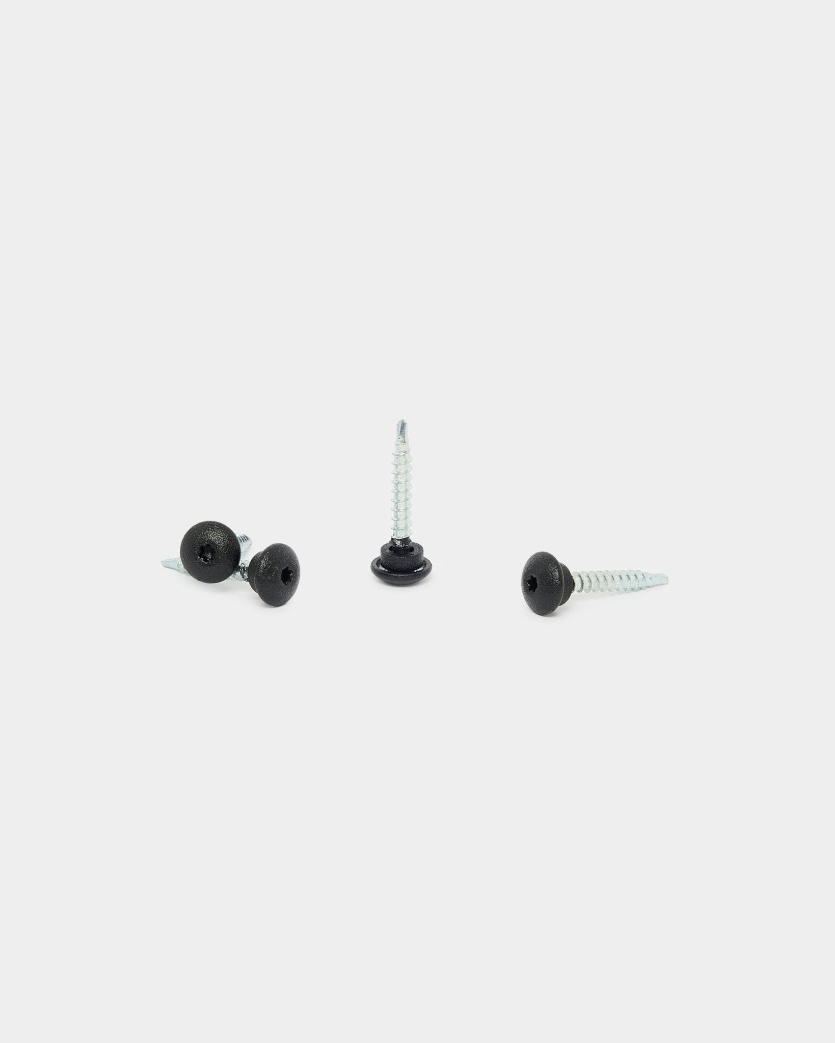 Three black WoodUpp 4.8x35 screws with Ø9.5 washers on a white background, designed as fasteners for Aluwood outdoor facade panels.