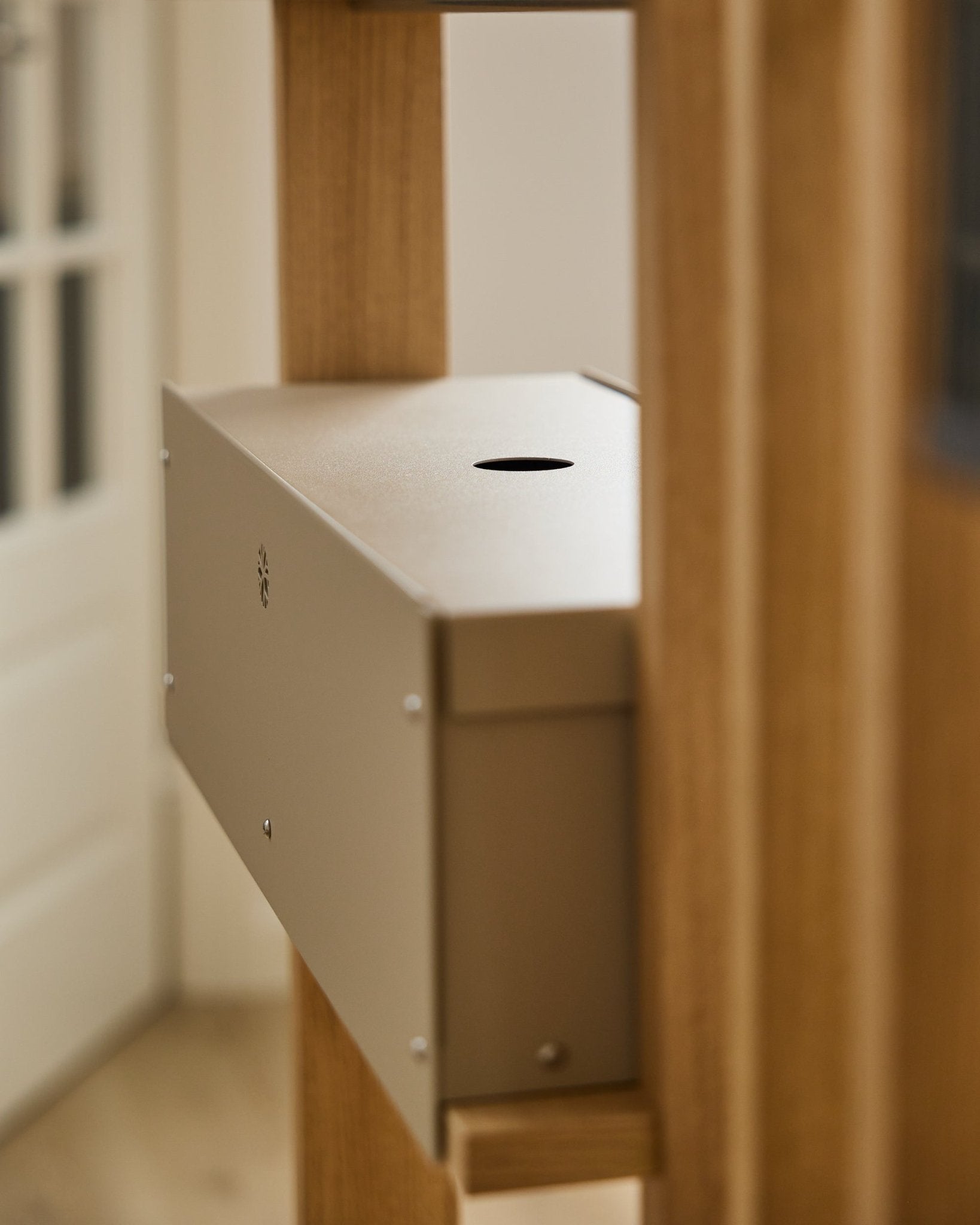 The Nell | Metal Box / BM2, Beige by WoodUpp is a powder-coated steel accessory from the CREATE collection, set between acoustic wood panels near a white door.